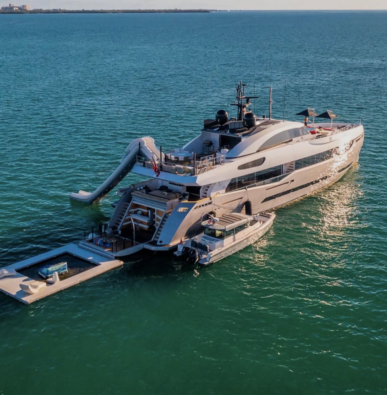 Superyacht at anchor with water slide, sea pool and chase boat